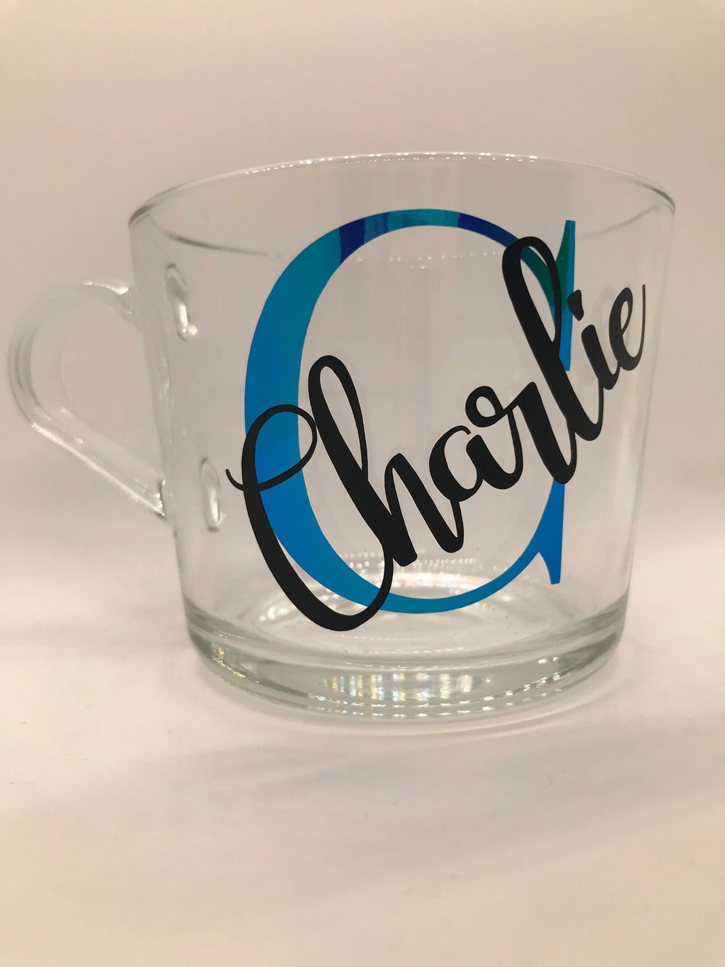 Clear glass mug with 'Charlie' printed on it against a white background