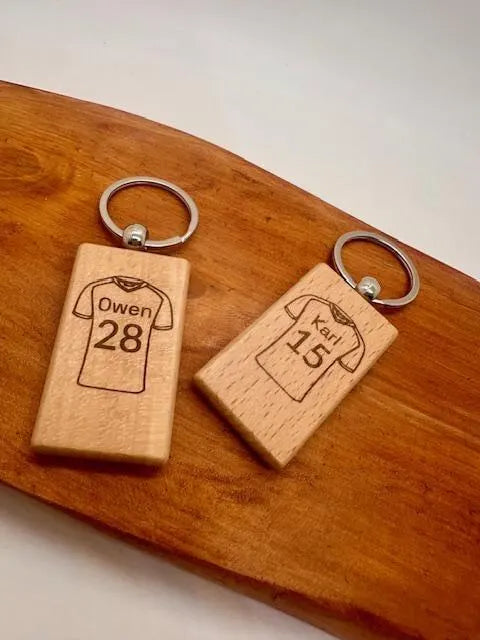 Two wooden keychains with laser-engraved football shirt designs
