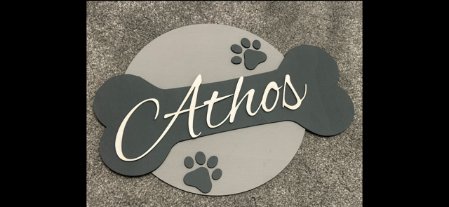 Personalized pet nameplate with paw prints on a textured surface