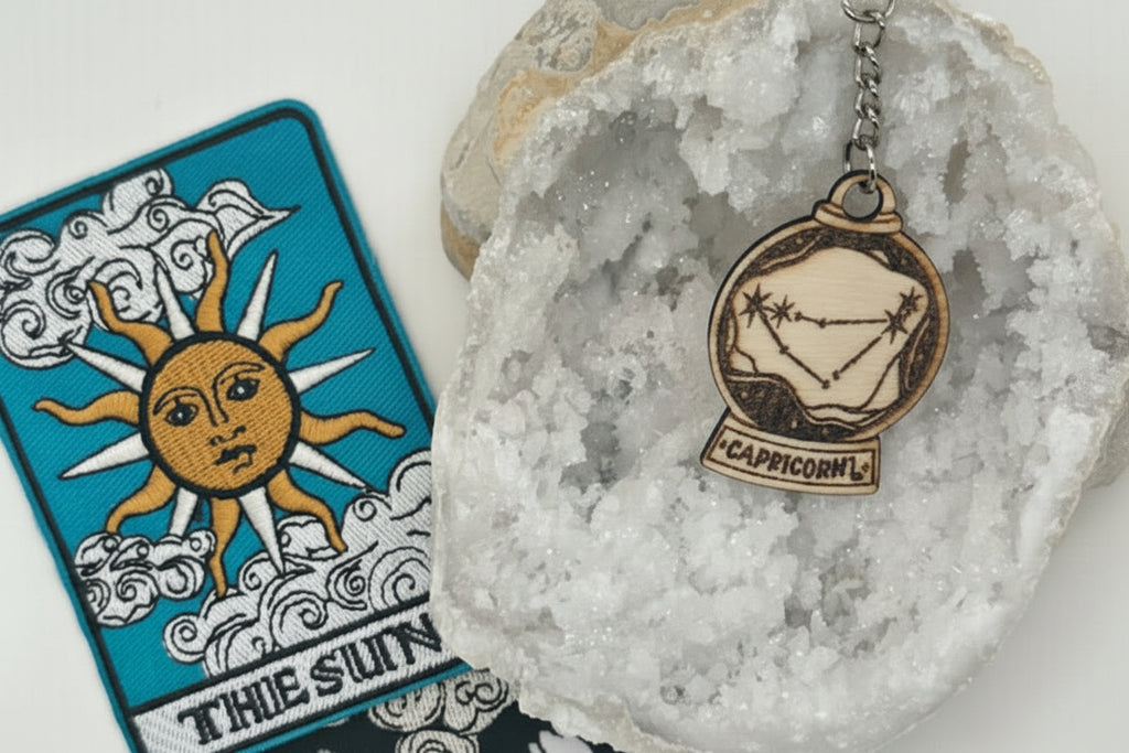 Zodiac keychain with star sign pendant on a crystal, tarot cards in the background