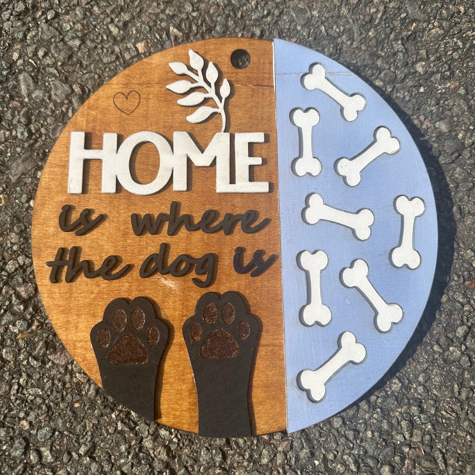 Round decorative sign with dog-themed text and graphics on
