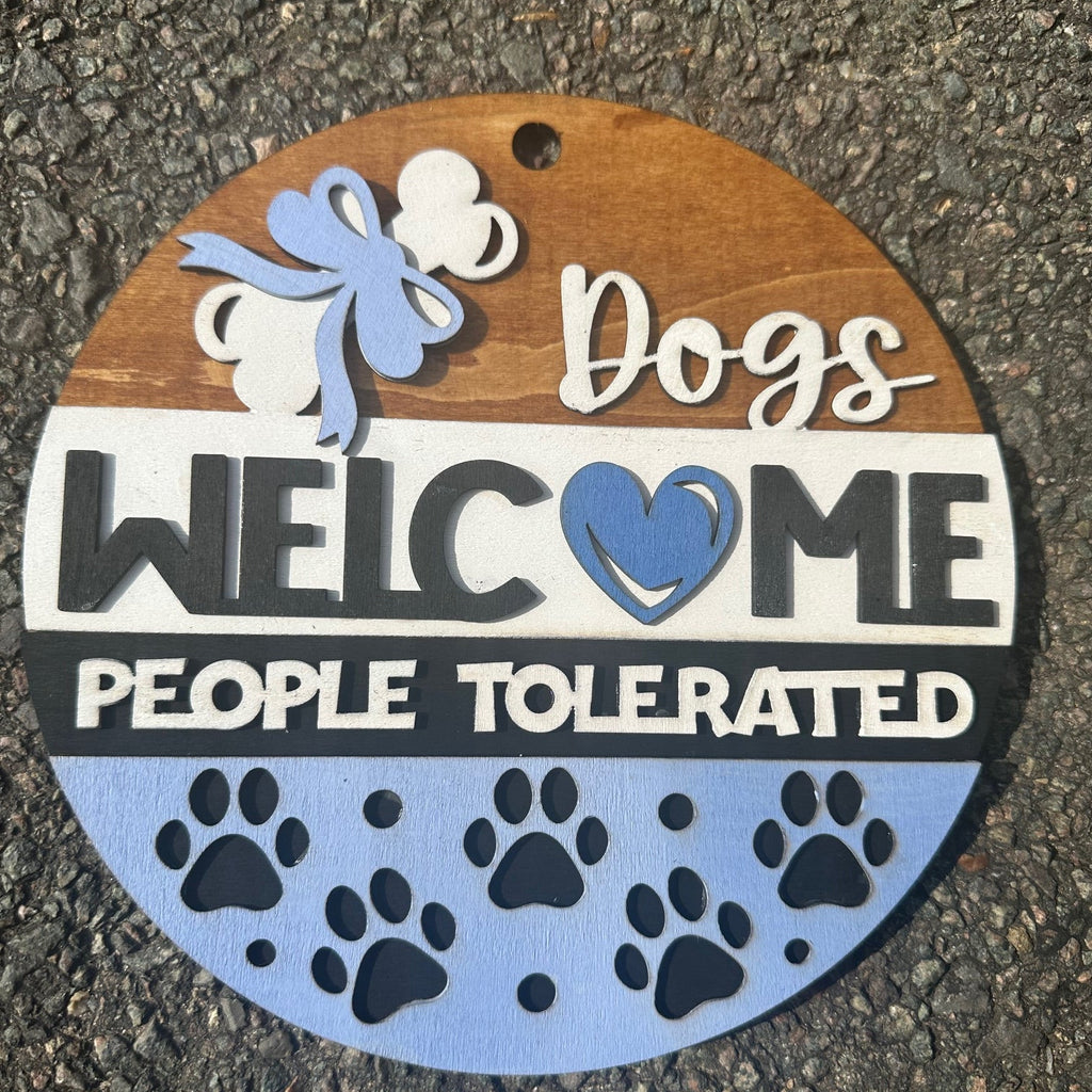 Round decorative dog sign with bones, paw prints, and text on